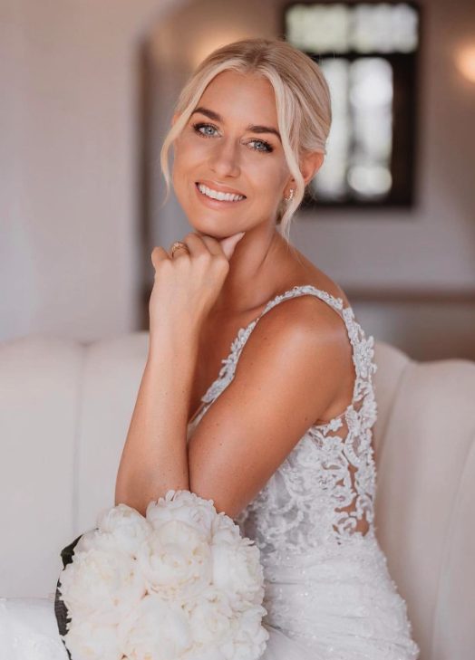 Bride on white sofa with peonies